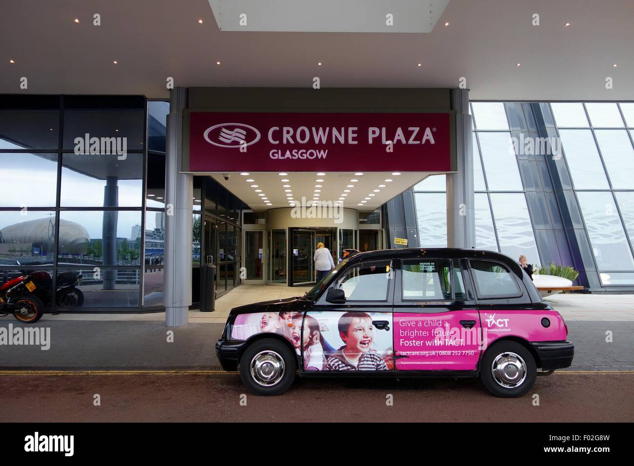 A Hackney taxi stopped outside the entrance of the Crowne Plaza hotel in Congress Rd, Glasgow, Scotland, Uk, Europe Stock Photo