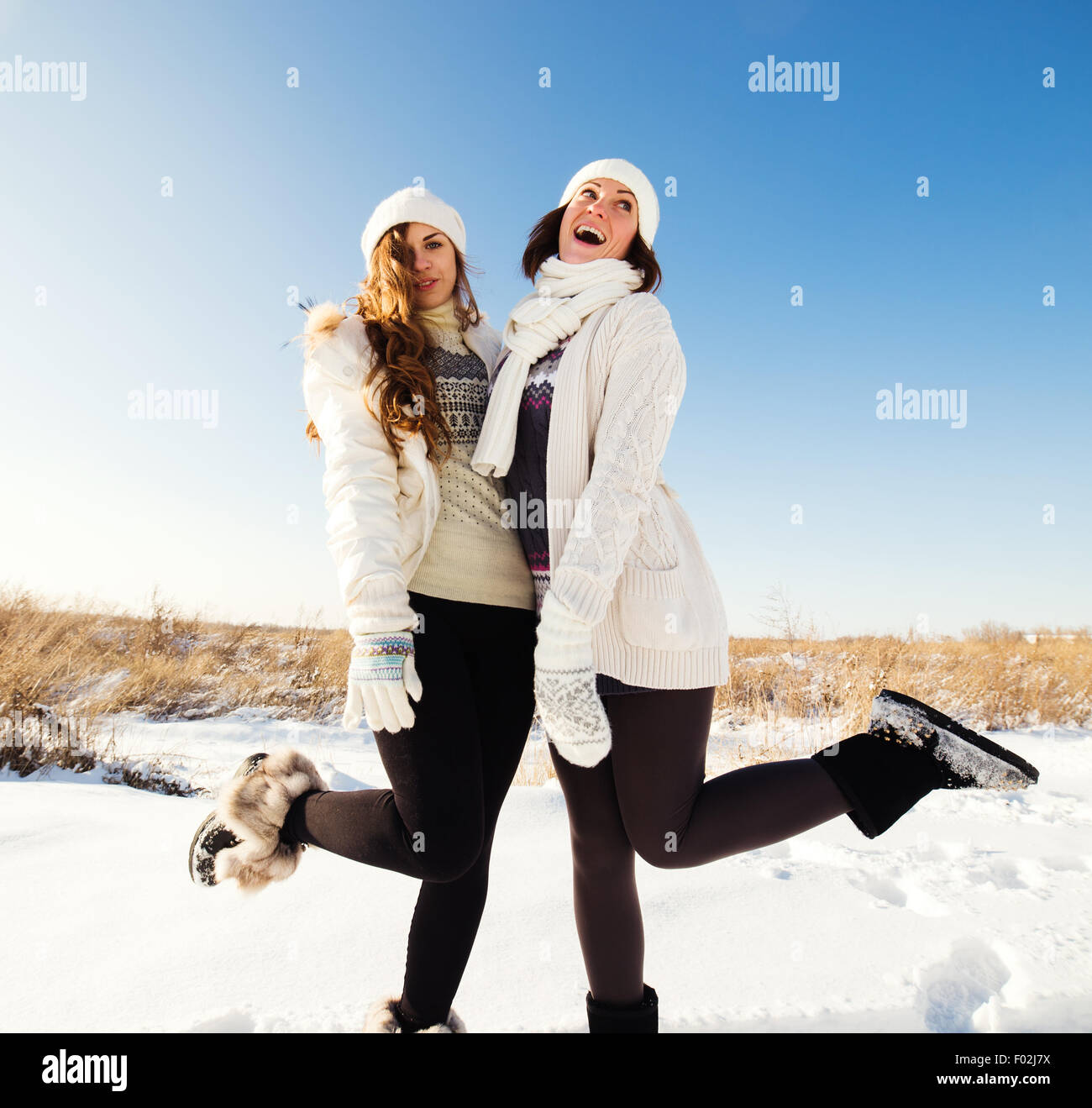 Two girlfriends have fun and enjoy fresh snow at beautiful winter day Stock Photo