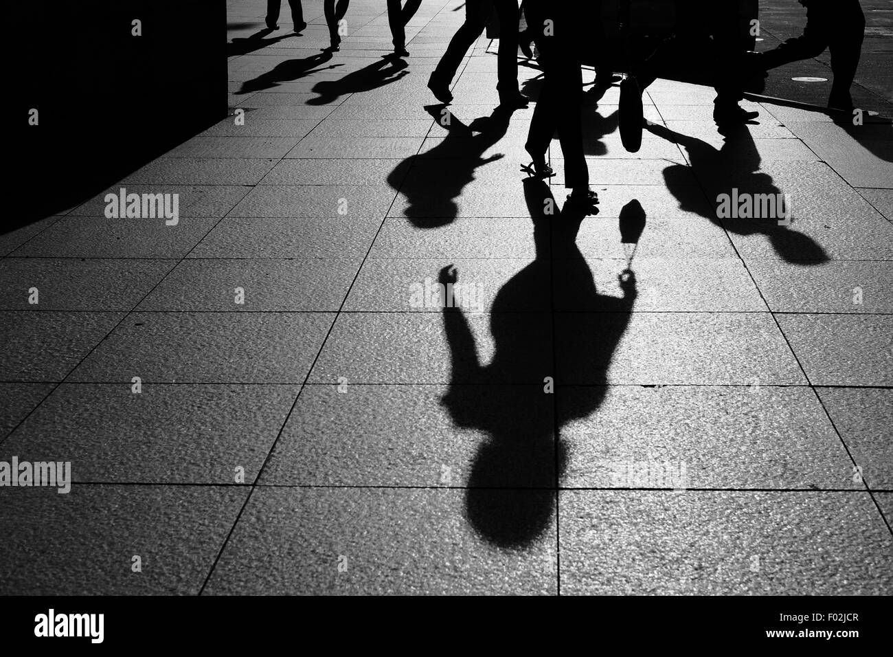 Shadows and Silhouettes of people walking on street in city Stock Photo