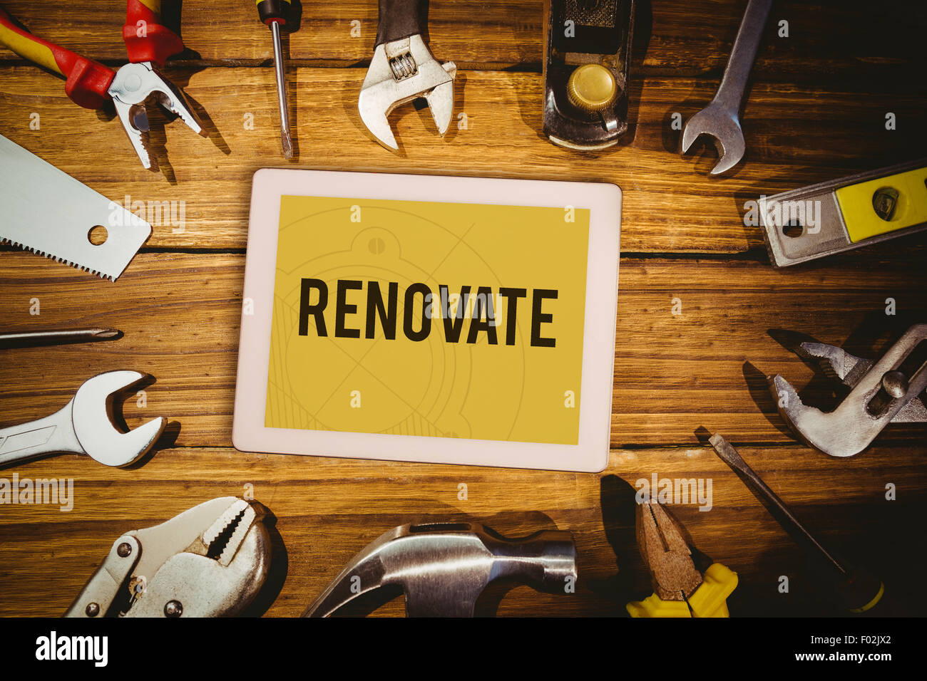 Renovate  against tablet on green background Stock Photo