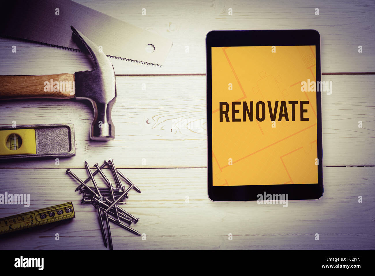 Renovate  against tablet displaying blueprint Stock Photo