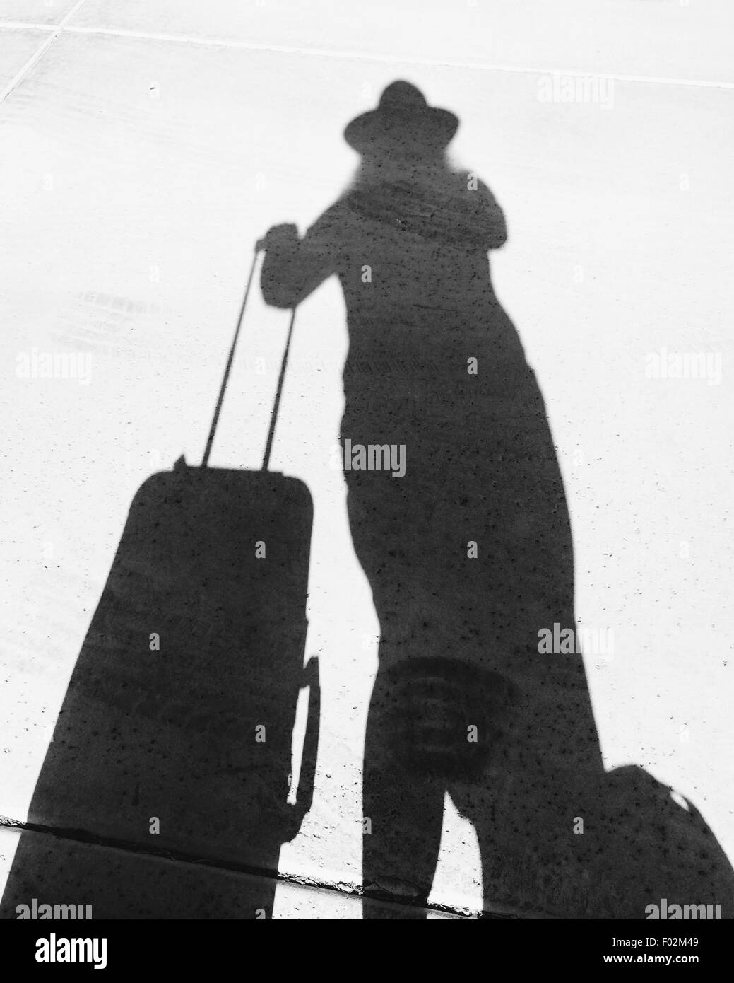 Shadow of a woman with a suitcase Stock Photo