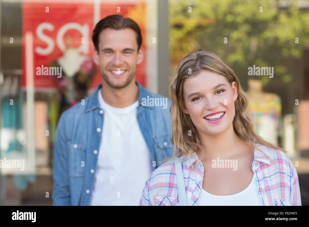 happy couple standing in front of a SALE sign Stock Photo - Alamy