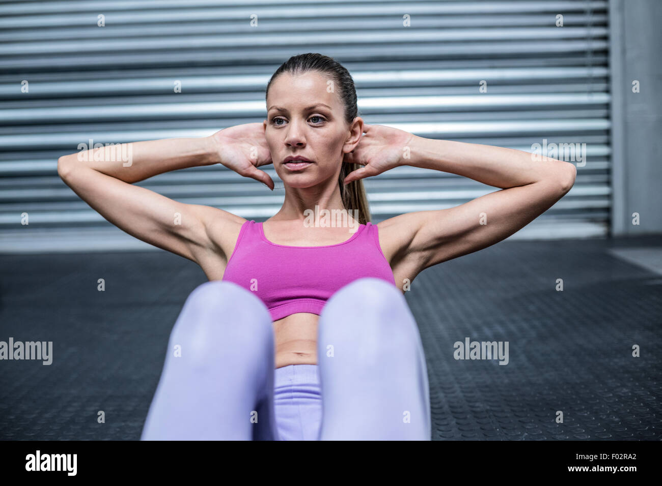 Muscular woman doing abdominal crunch Stock Photo
