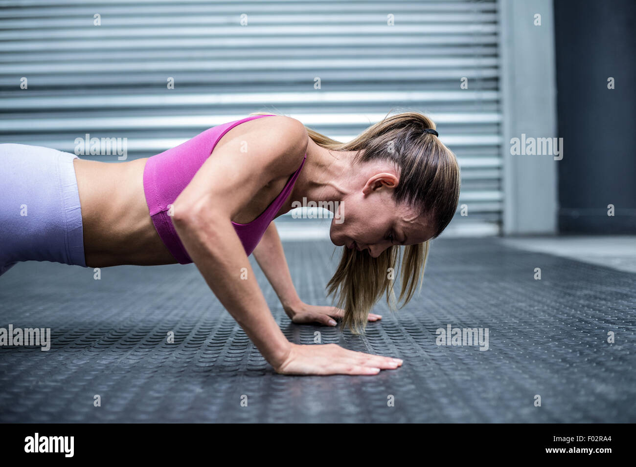 Muscular woman doing push ups Stock Photo