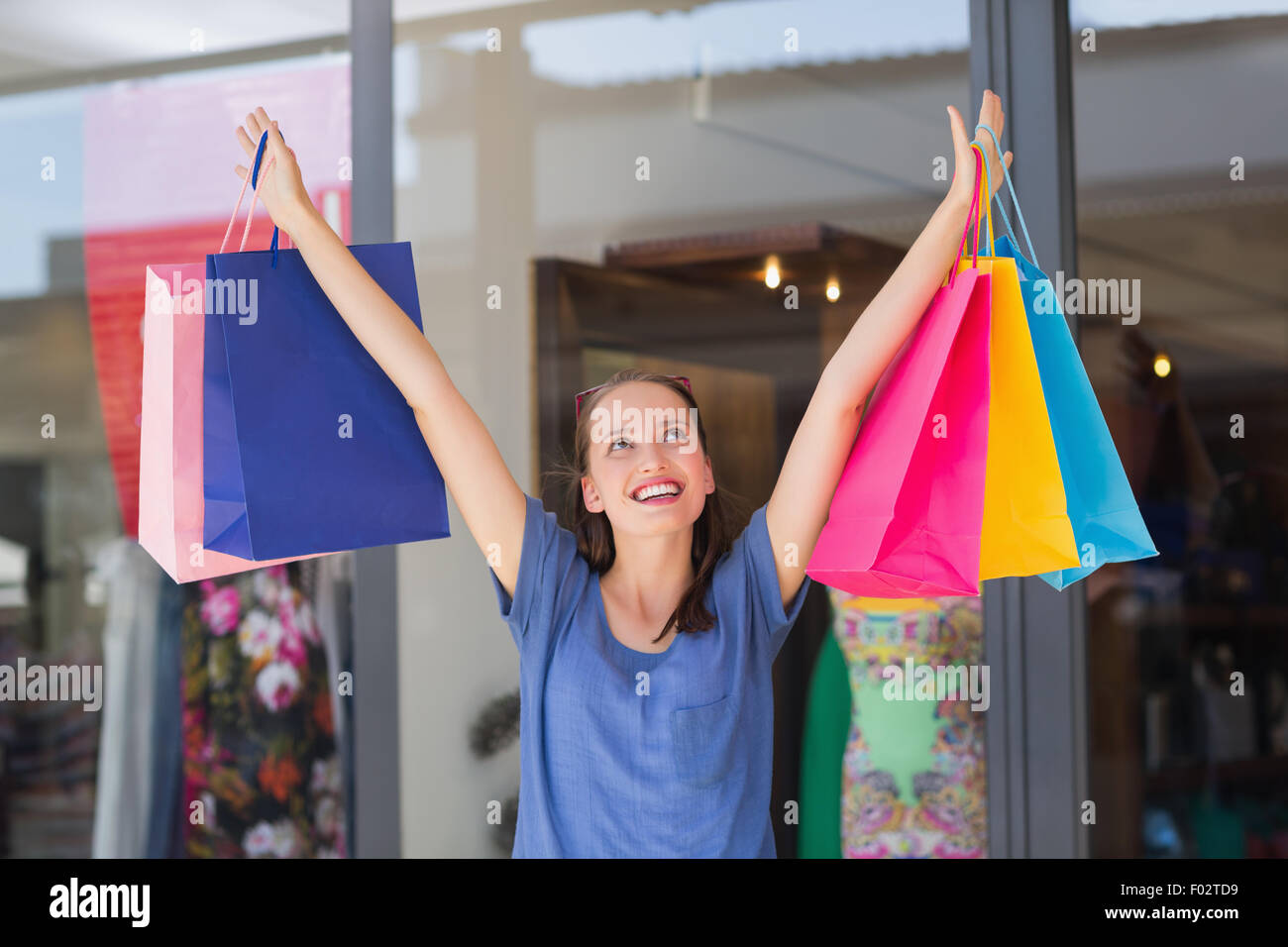 Energetic woman handing shopping bags Stock Photo