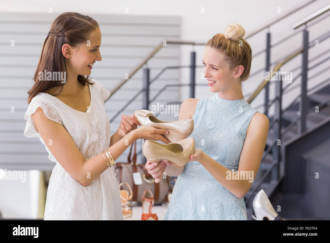 Happy women looking at heel shoes Stock Photo