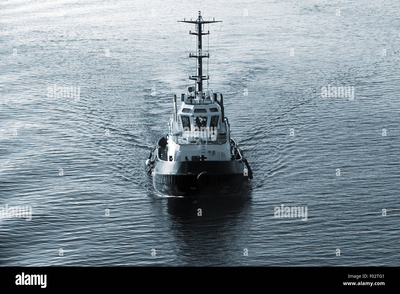 Tug boat underway, front view, dark blue tonal correction filter, retro style Stock Photo