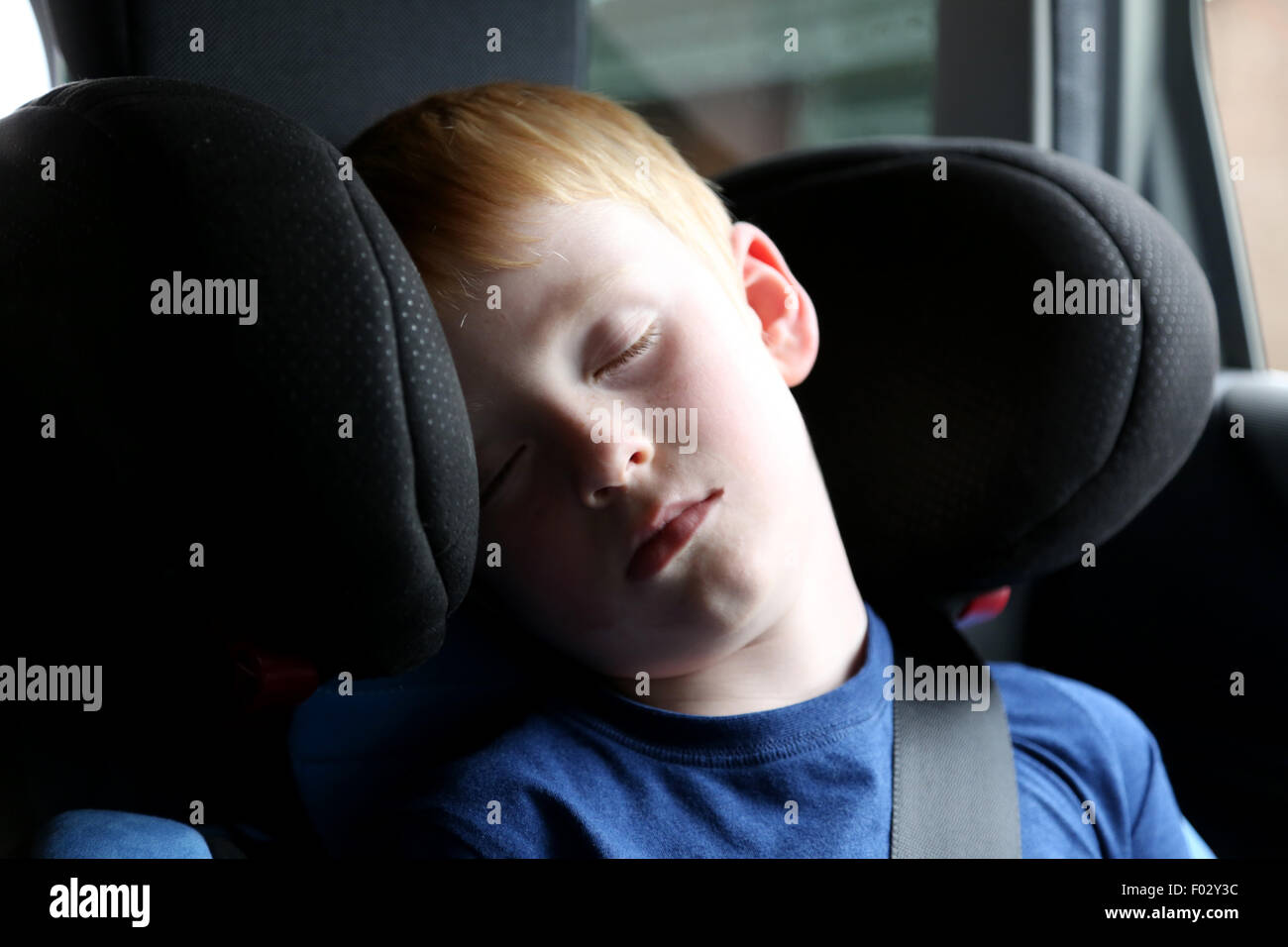 A young child asleep in a childs car seat Stock Photo