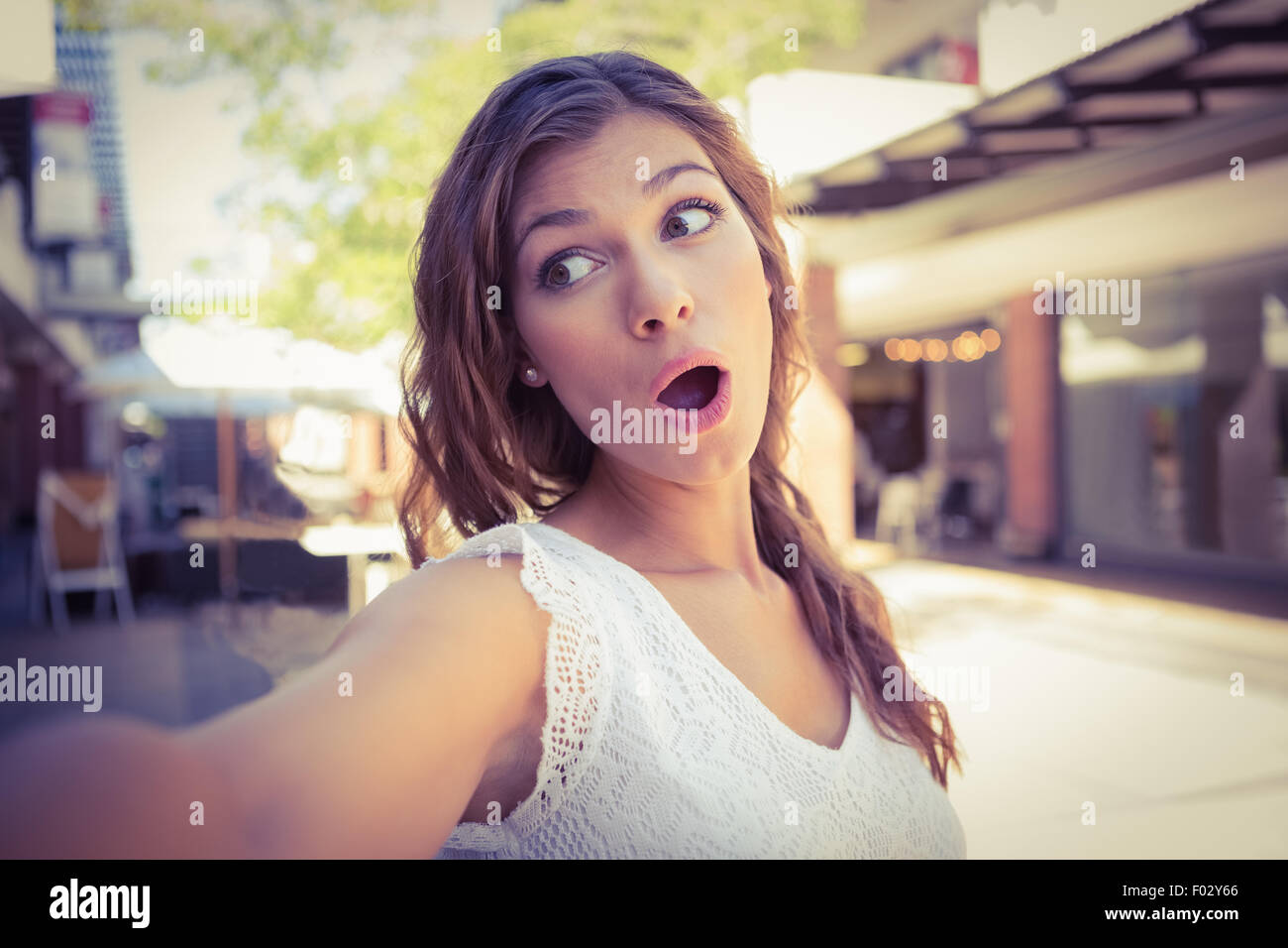 Astonished woman holding camera Stock Photo