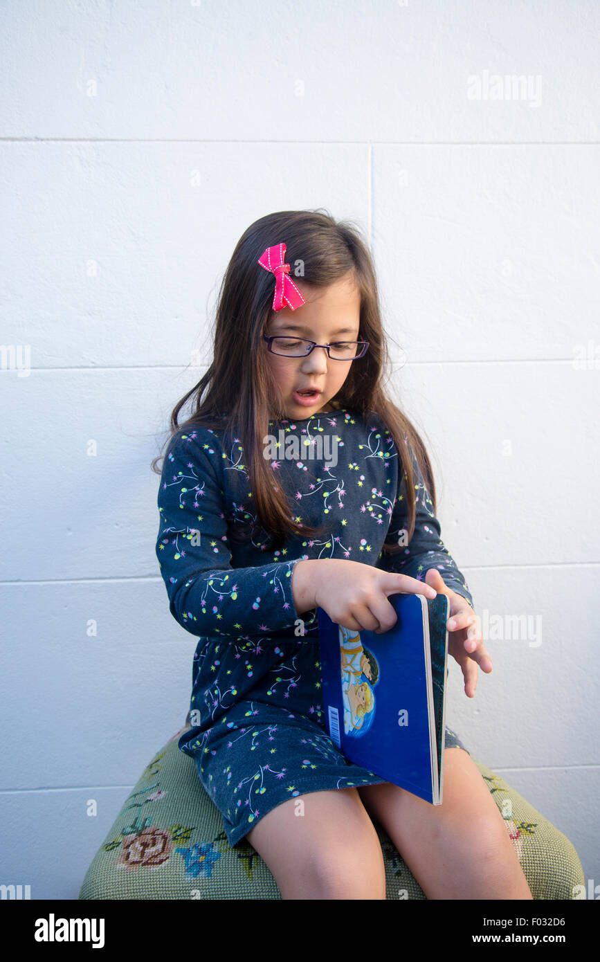 Five year old girl reading book Stock Photo