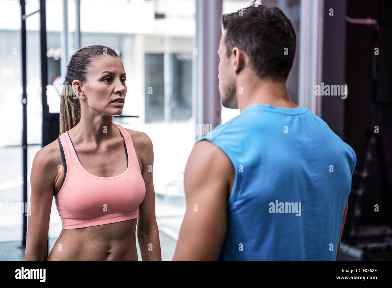Young worried bodybuilder talking to her colleague Stock Photo - Alamy