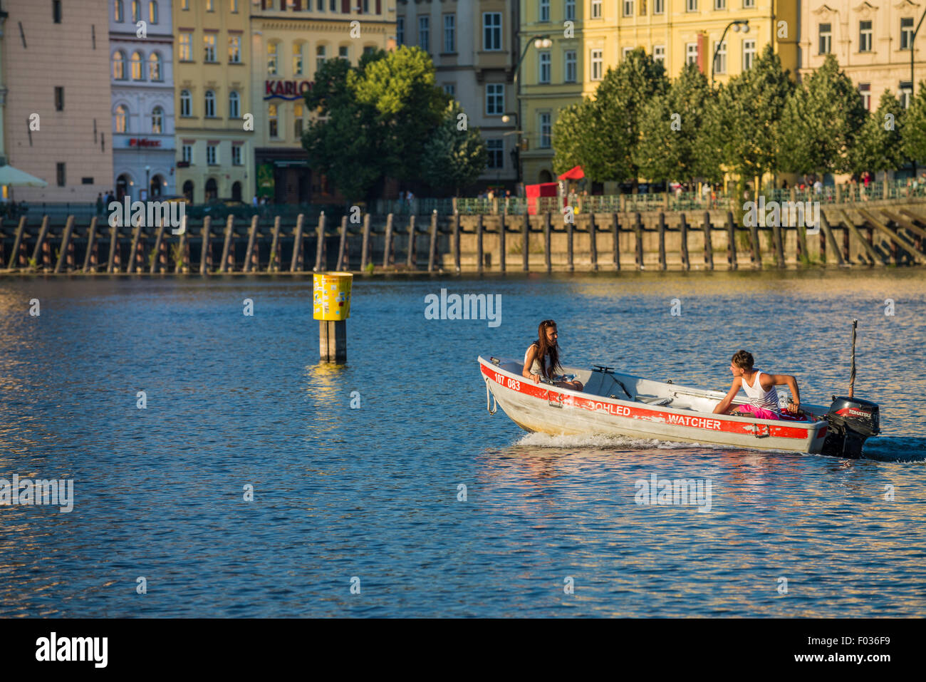 People in carshaped paddle boats in Vltava River with Charles bridge