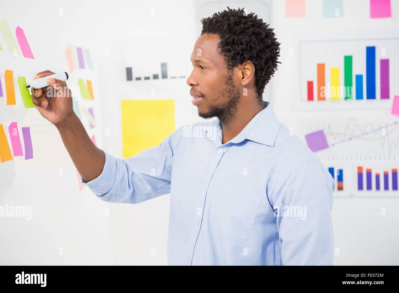 Young creative businessman writing on sticky notes Stock Photo - Alamy