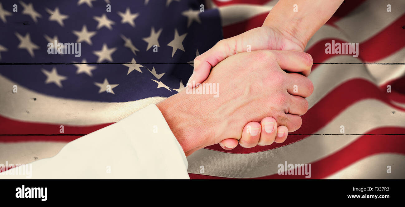 Composite image of extreme closeup of a doctor and patient shaking hands Stock Photo