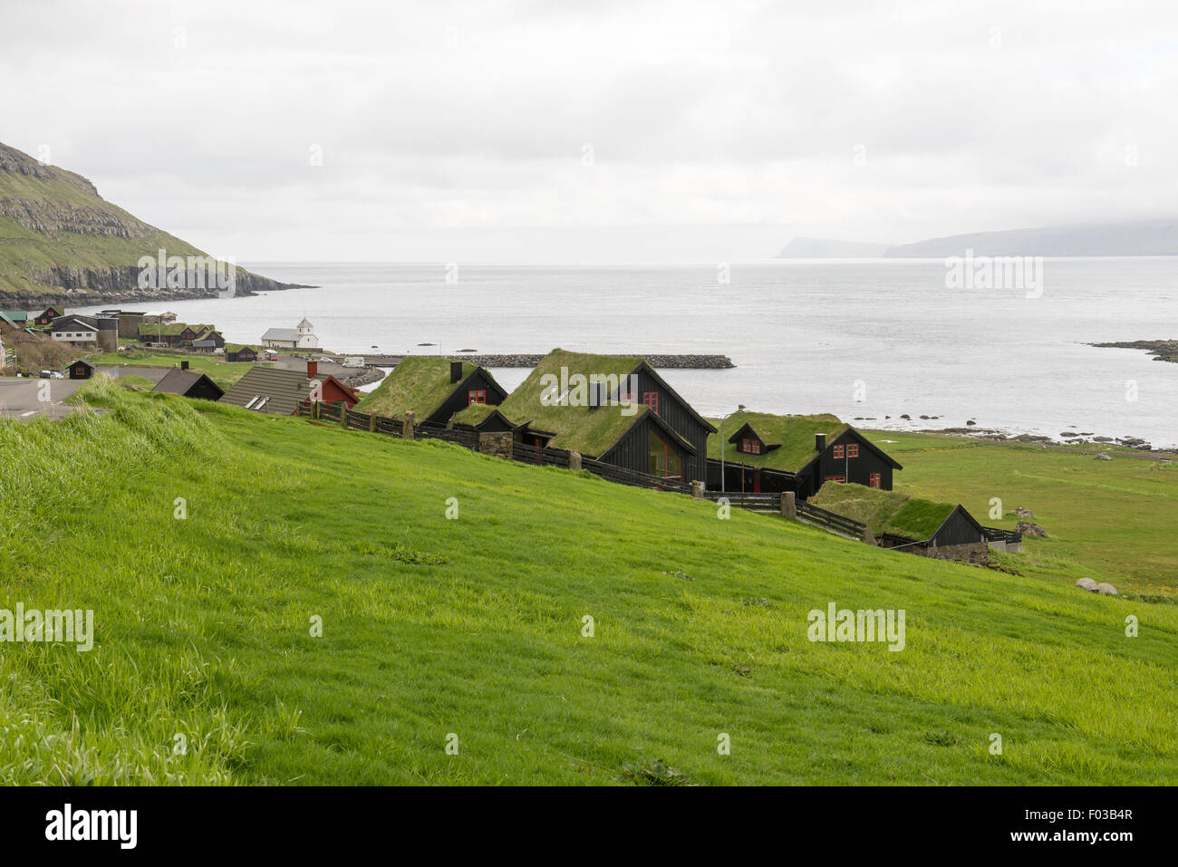Kirkjubøur on the Faroe Islands with typical houses, church and road Stock Photo