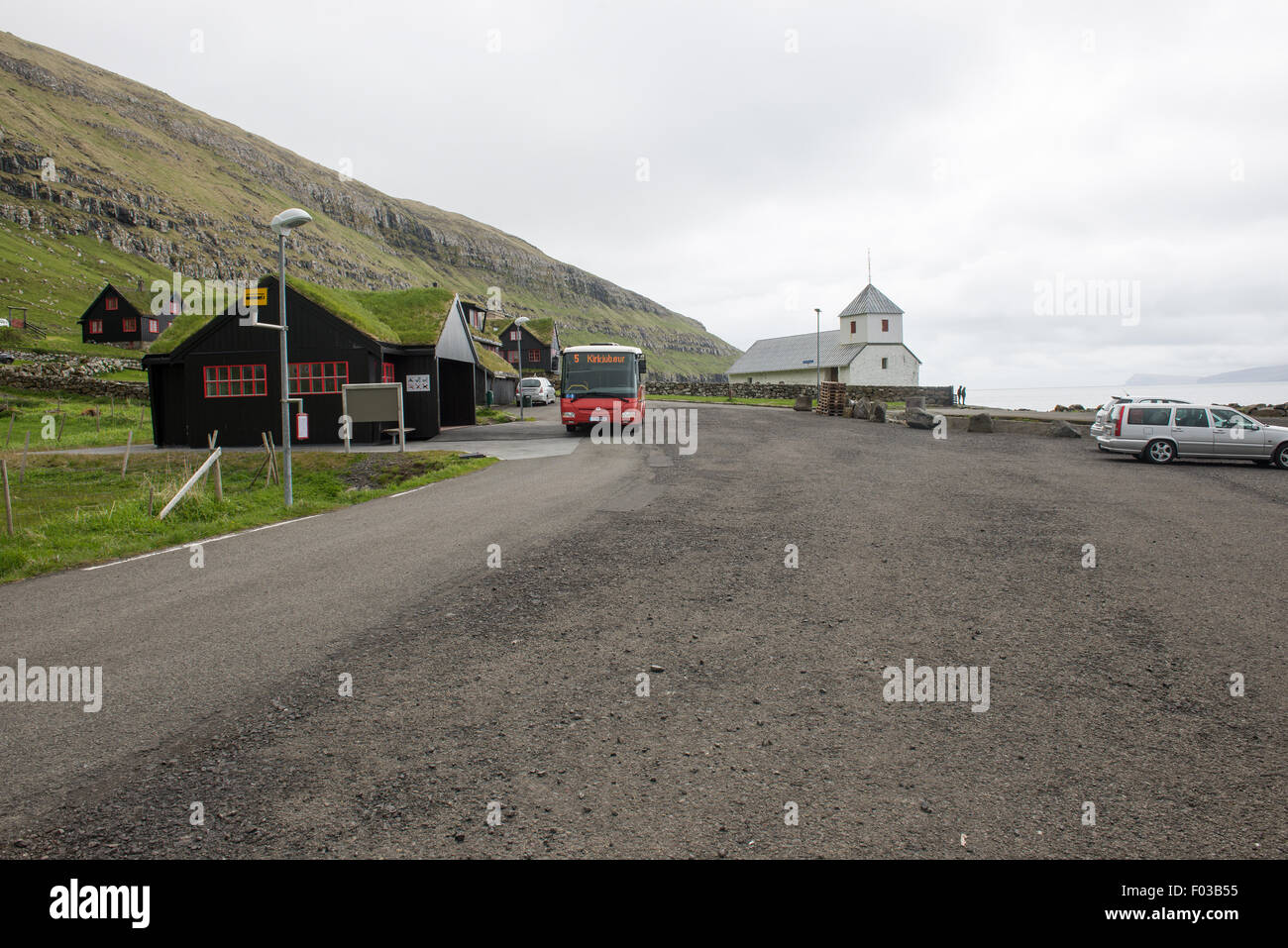 Kirkjubøur on the Faroe Islands with typical houses, church and bus Stock Photo