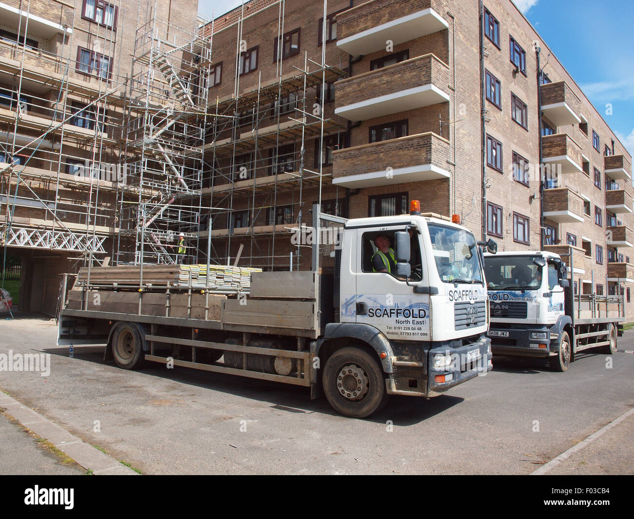 Two scaffolding trucks delivering tubular pipe steel to a listed building for renovation work of that building to be completed. Stock Photo