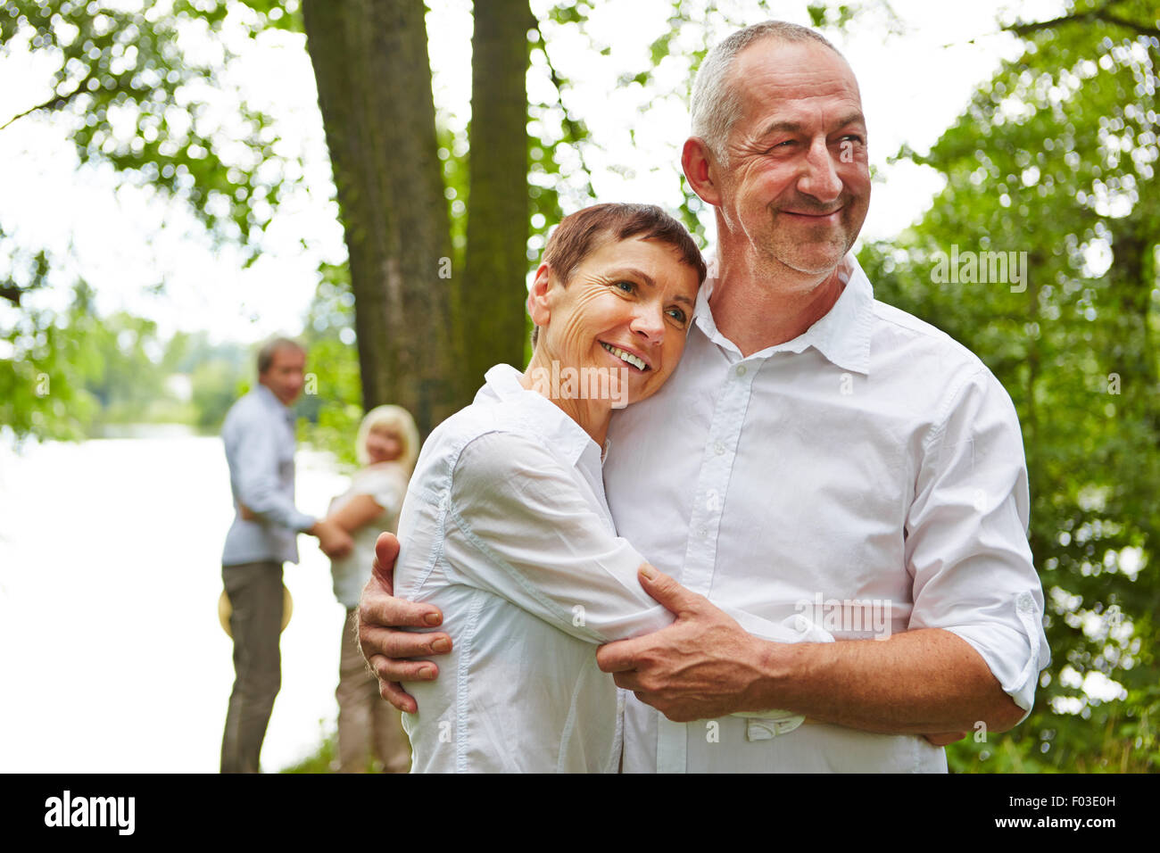 Senior couple in love embracing in nature in summer Stock Photo