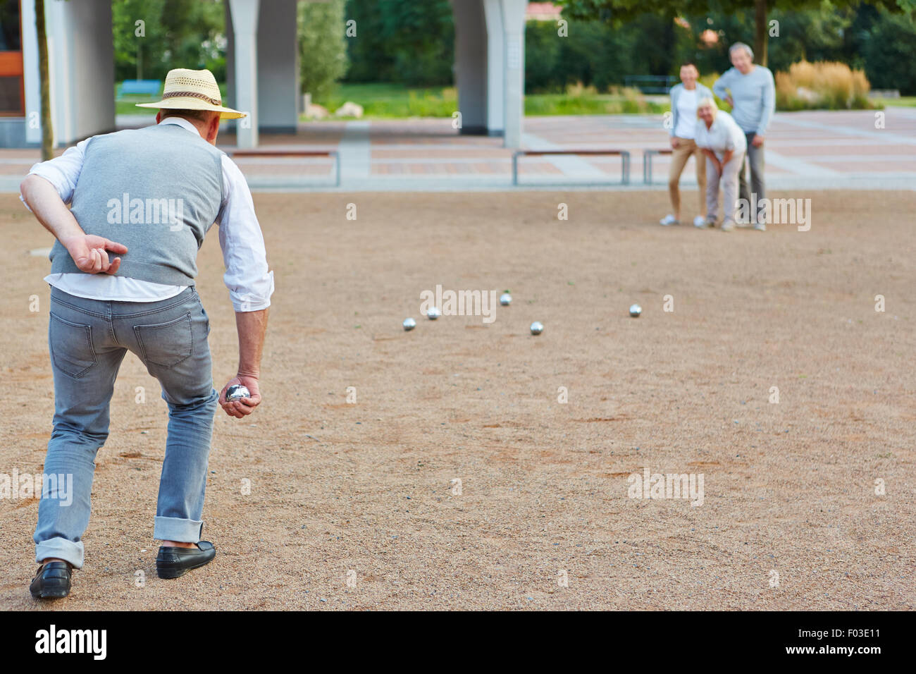 Senior group playing boule together in a city in front of a retirement hime Stock Photo
