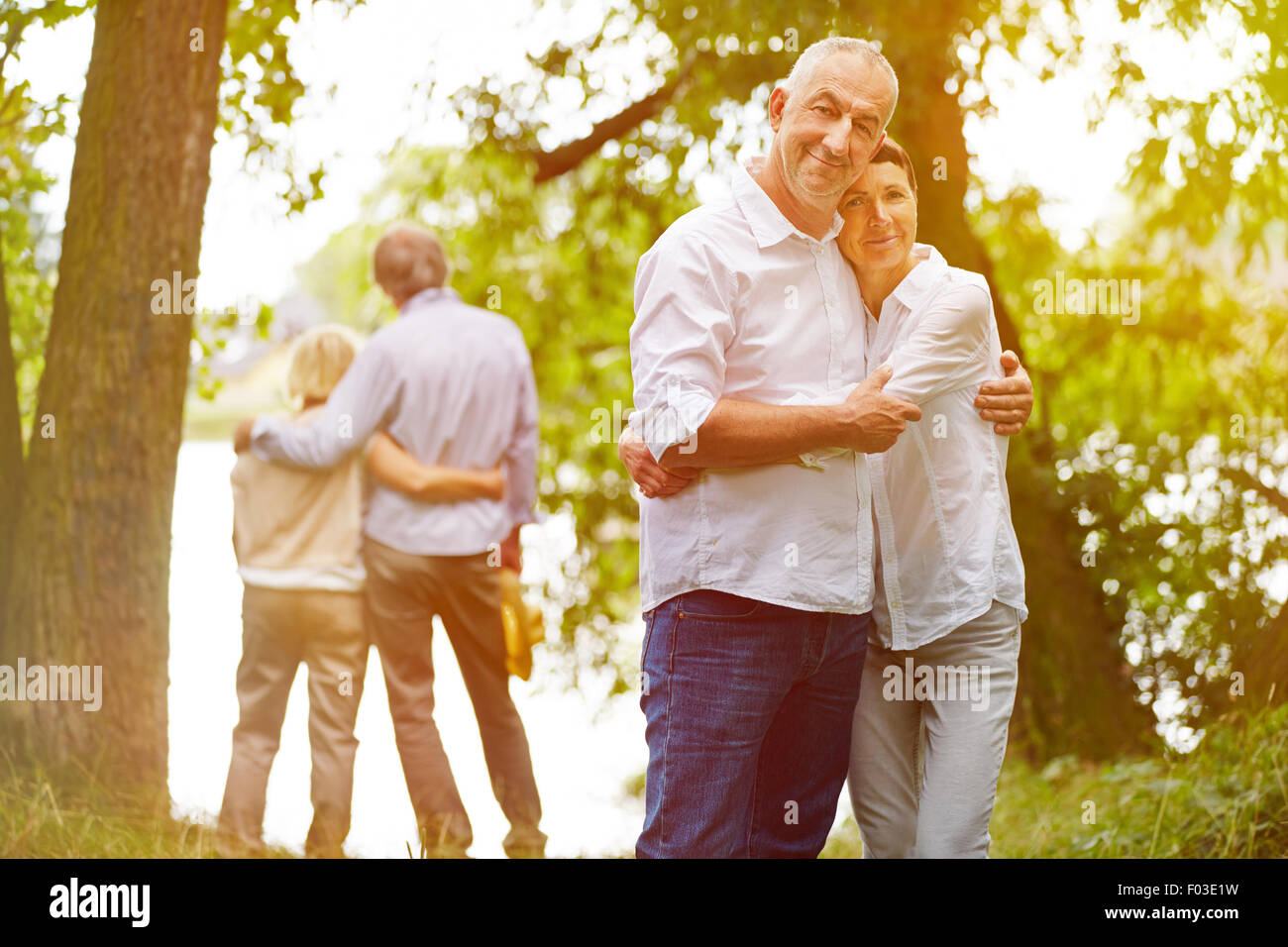 Two happy senior couples in garden of nursing home in summer Stock Photo