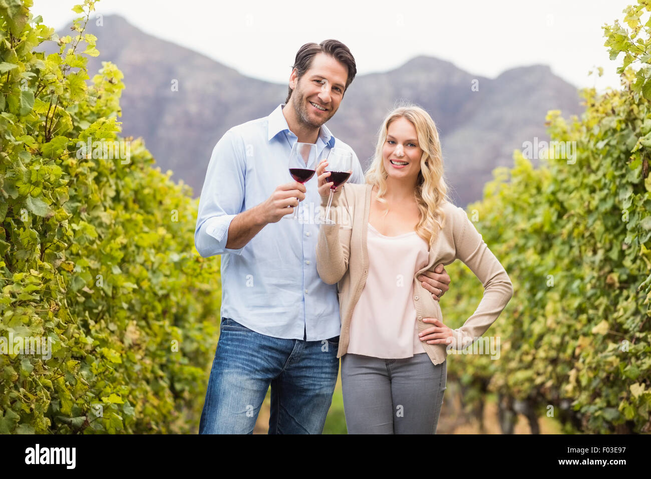 Young happy couple holding a glass of wine and looking at camera Stock ...