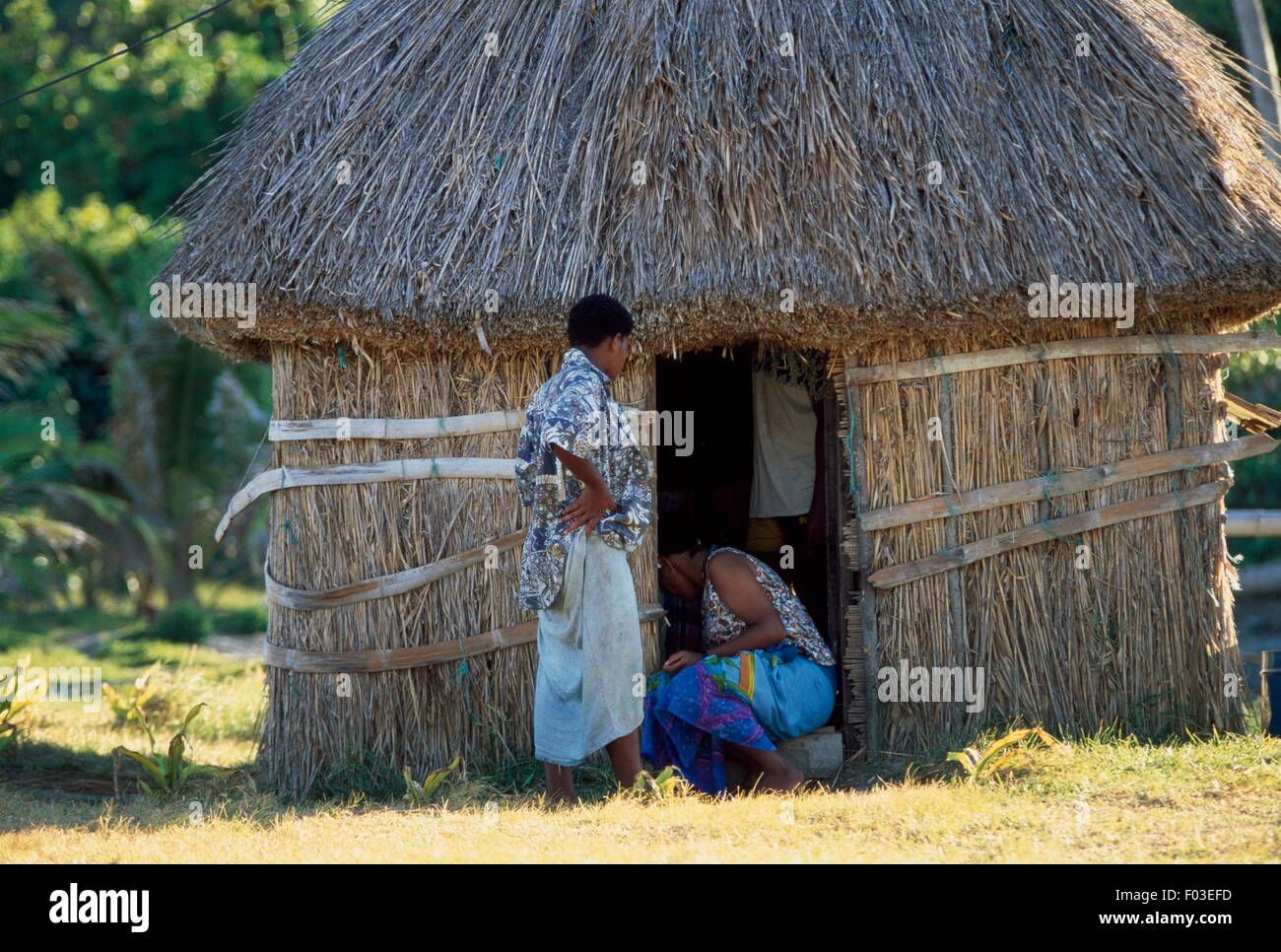 Women in front of a typical Fijian straw hut (bure), village of Dalomo, Yasawa Island, Fiji. Stock Photo