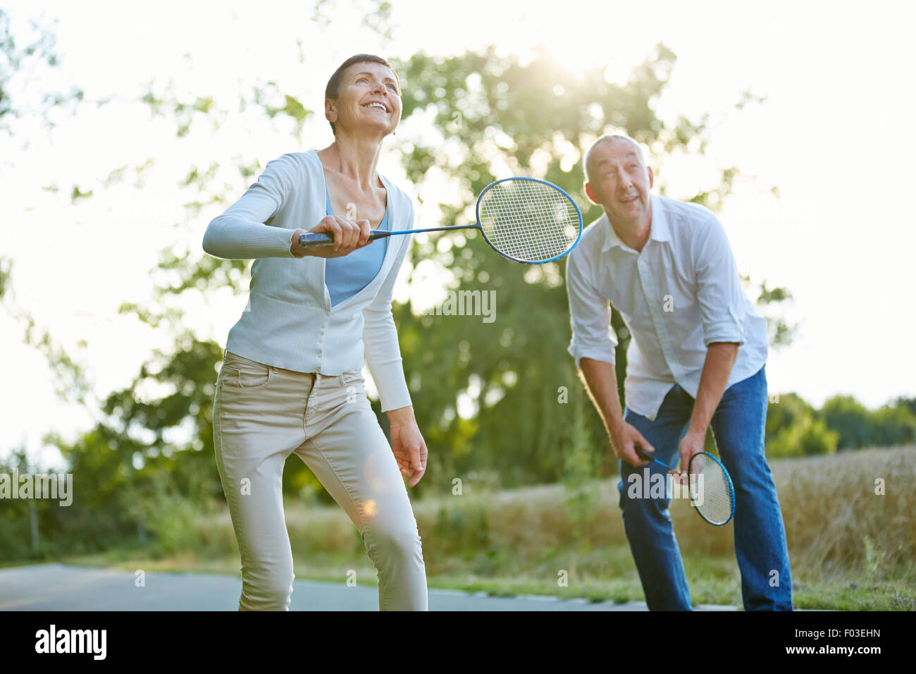 Senior couple playing badminton in summer in nature Stock Photo