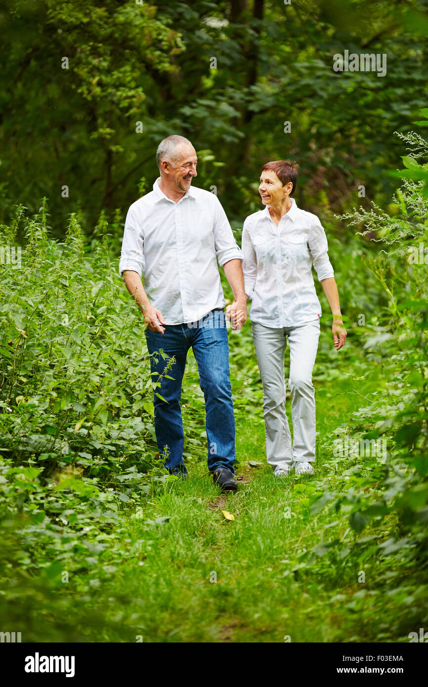 Happy senior couple taking a walk in nature in summer Stock Photo - Alamy
