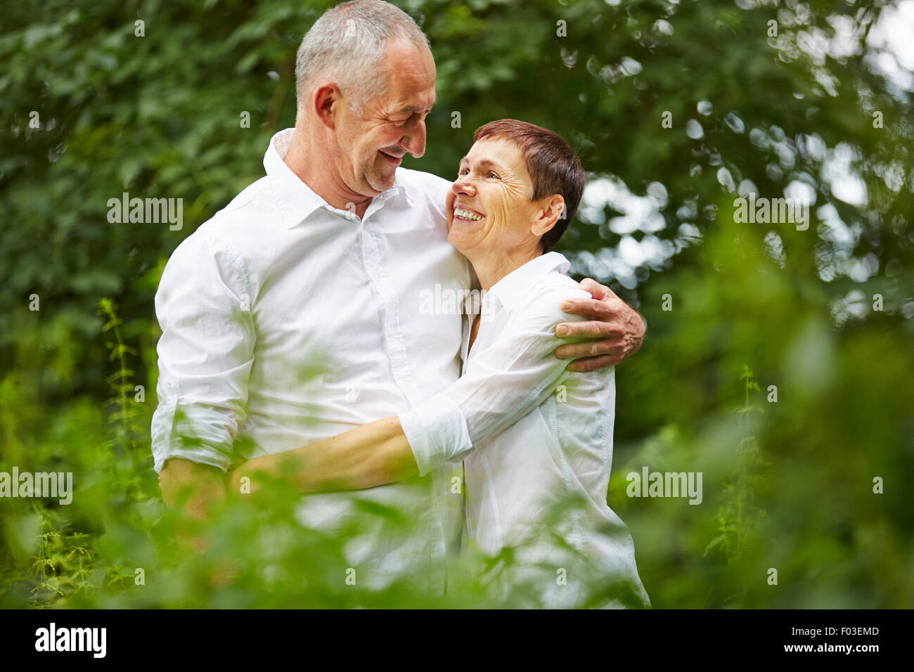 Senior couple in love embracing each other in nature in summer Stock Photo