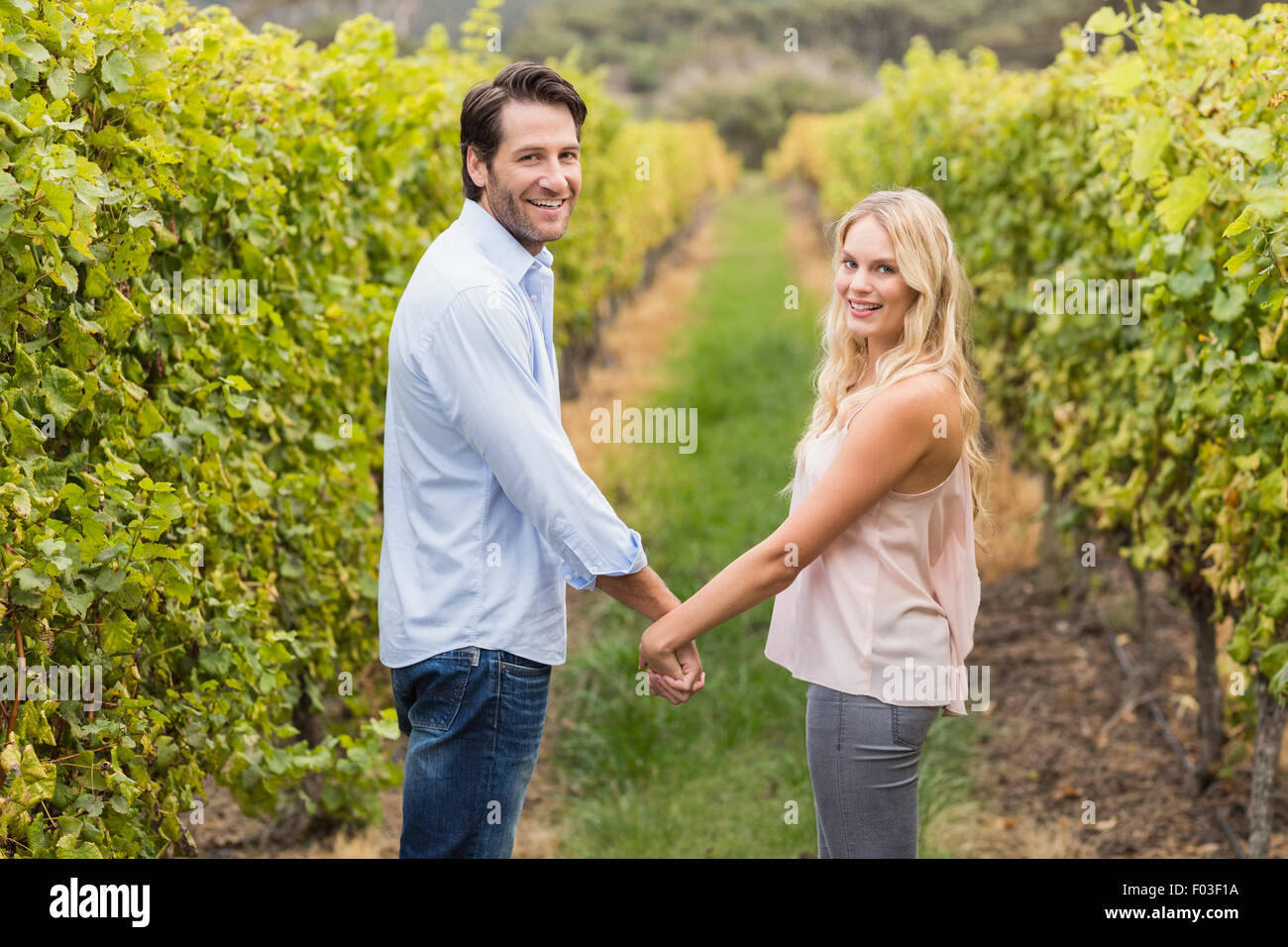 Young happy couple holding hands and looking at camera Stock Photo - Alamy