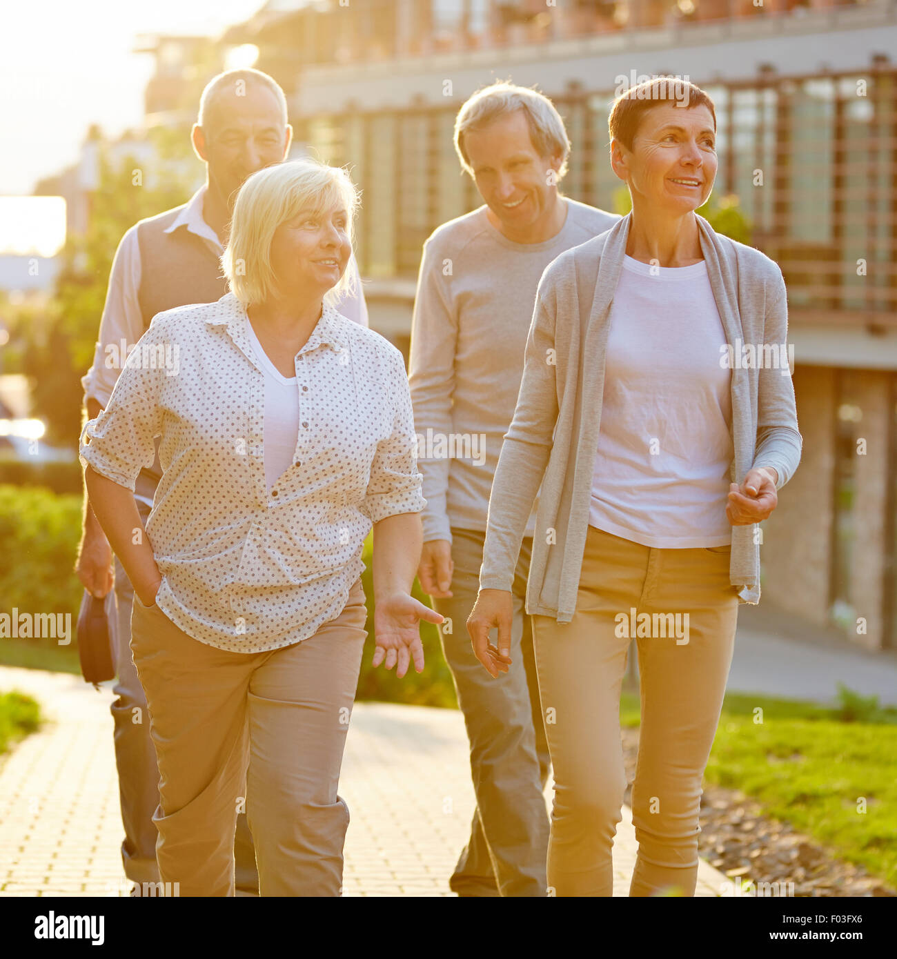 Happy senior travel group walking in a city in summer Stock Photo
