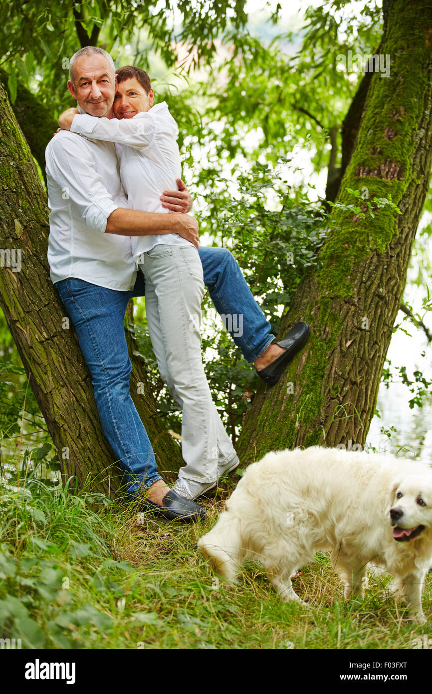 Senior couple taking dog for walk in nature in summer Stock Photo - Alamy