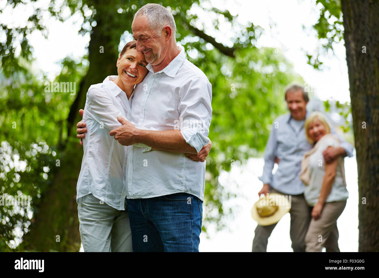 Two happy smiling senior couples in garden of retirement home Stock Photo