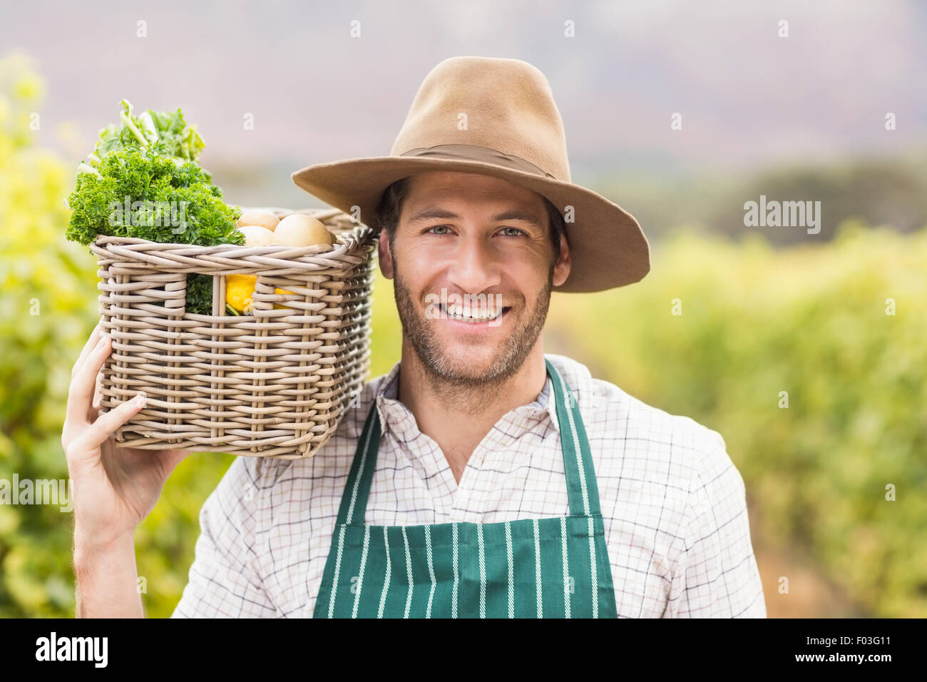 Young happy farmer holding a basket of vegetables Stock Photo - Alamy