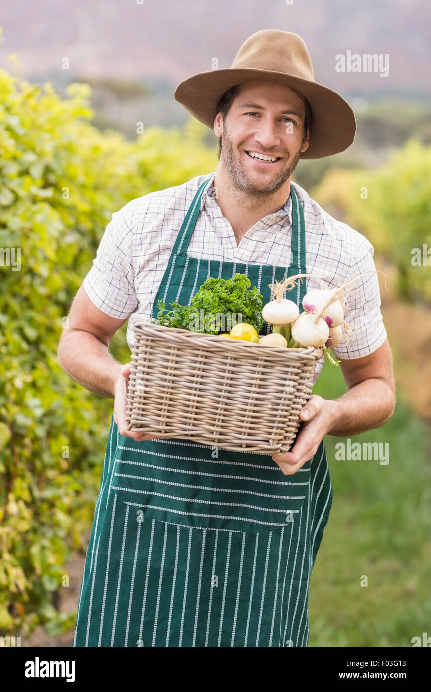 Young happy farmer holding a basket of vegetables Stock Photo - Alamy
