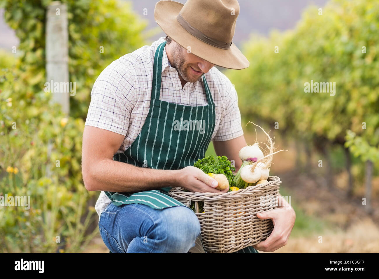 Young happy farmer holding a basket of vegetables Stock Photo - Alamy
