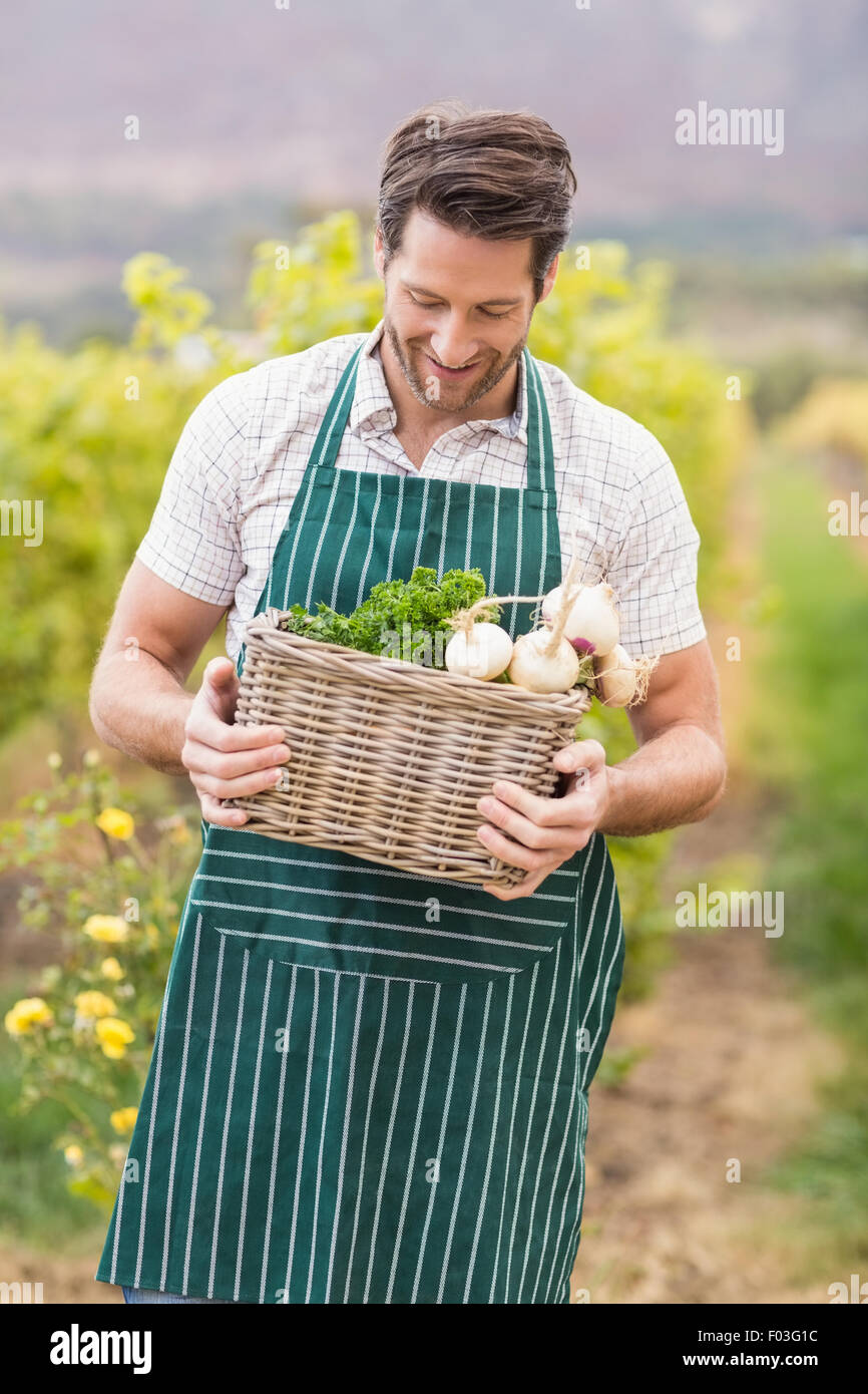 Young happy farmer holding a basket of vegetables Stock Photo - Alamy