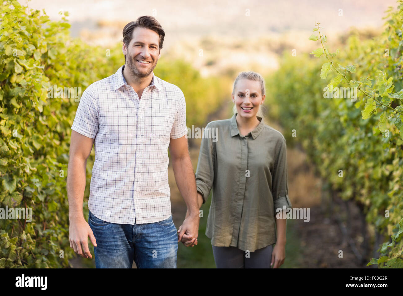 Two young happy vintners holding hands Stock Photo