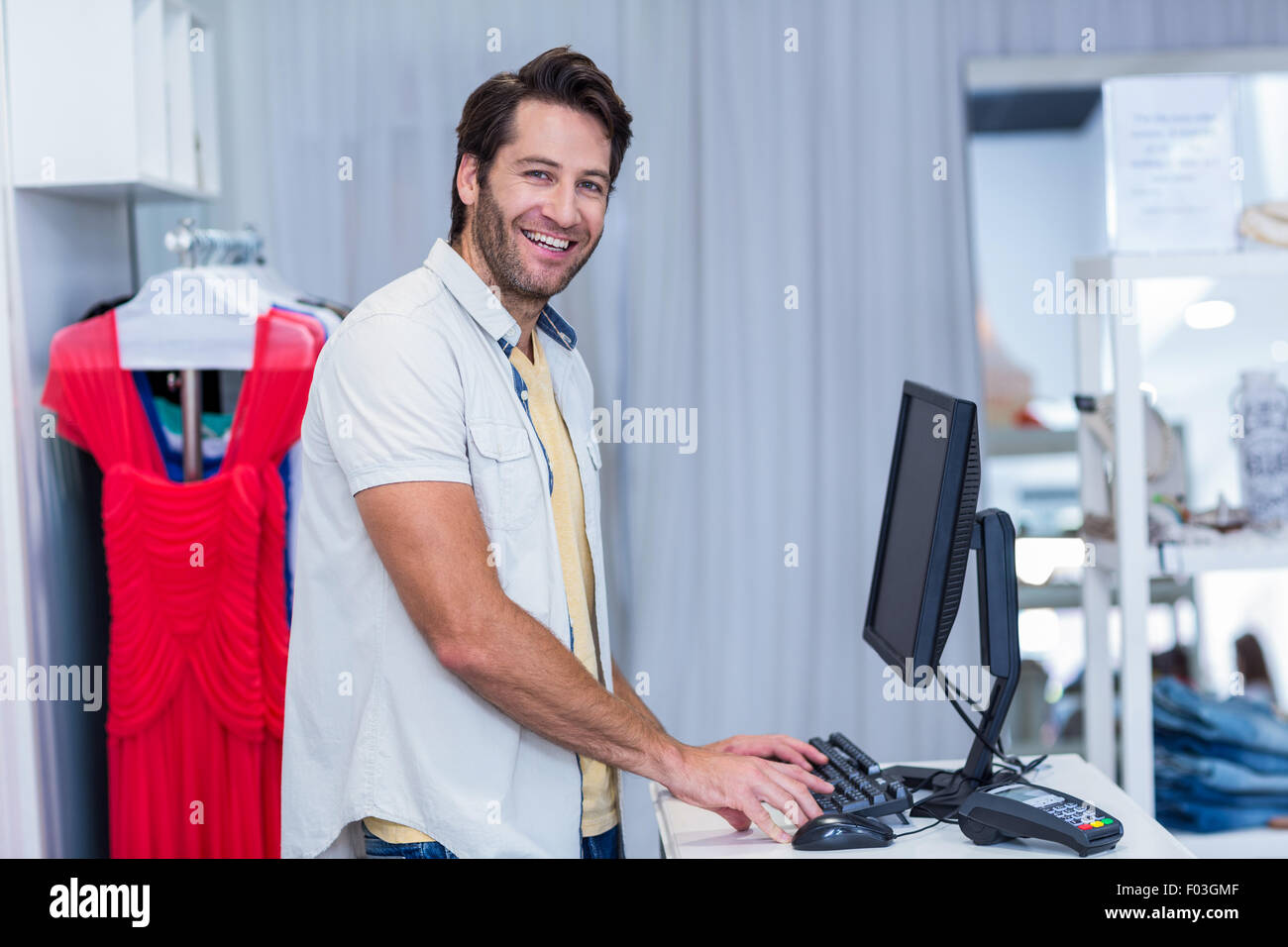 Smiling cashier typing Stock Photo