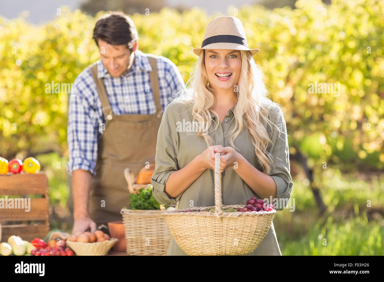 Blonde customer holding a vegetables basket Stock Photo - Alamy
