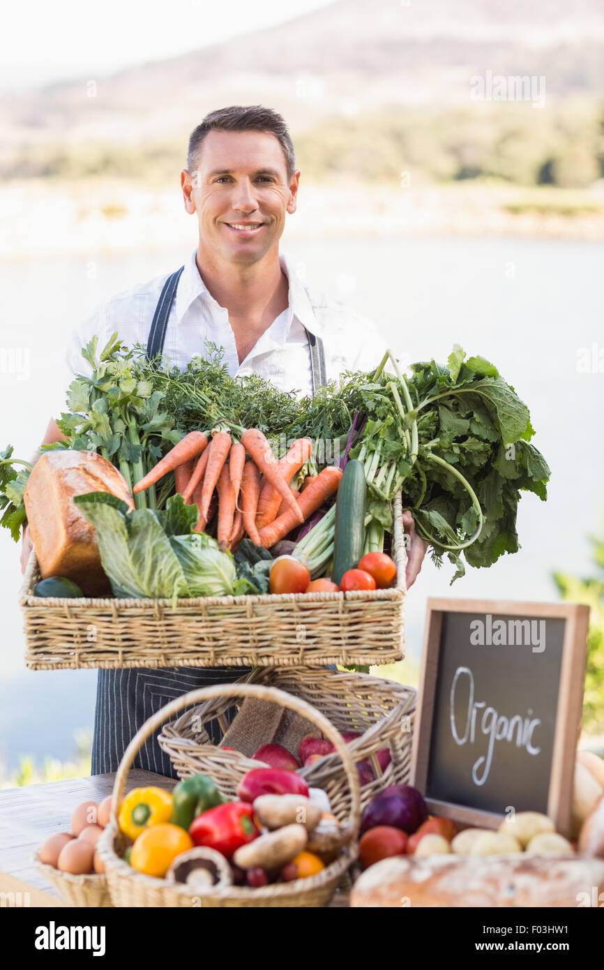 Smiling farmer holding a basket of vegetables Stock Photo - Alamy