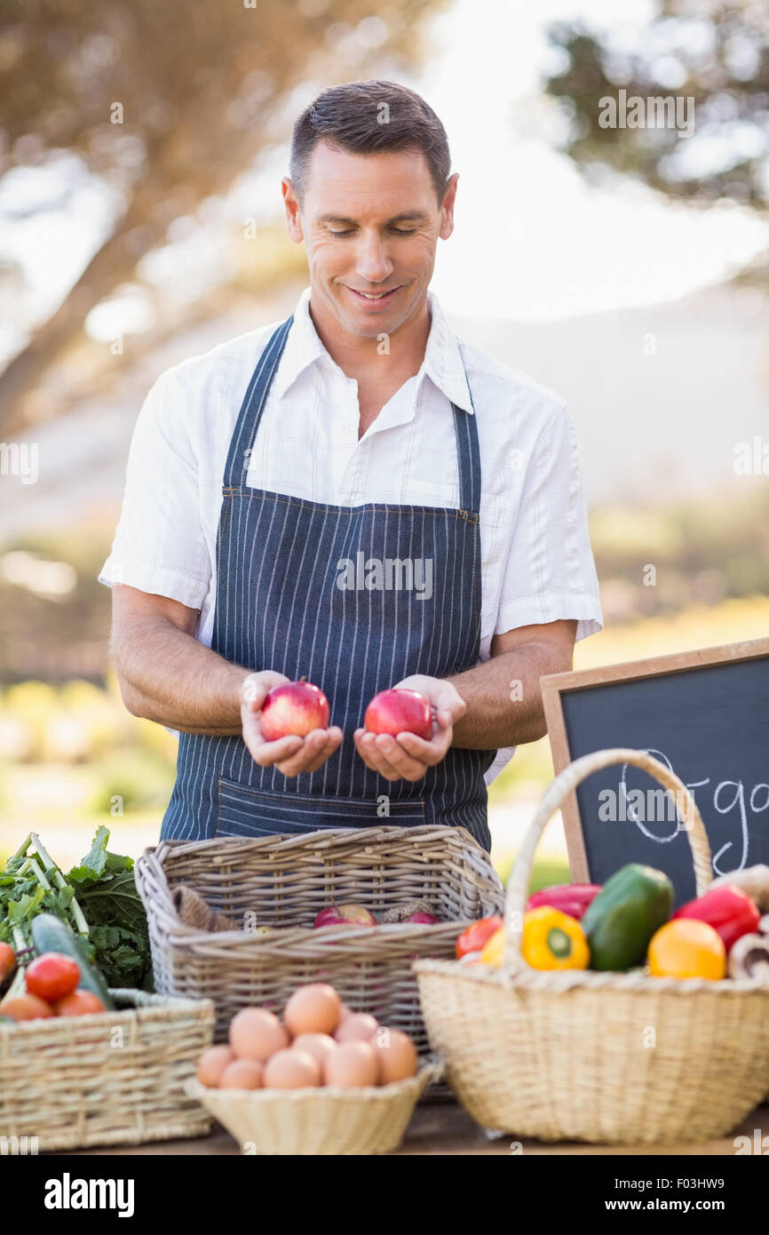 Smiling farmer holding two red apples Stock Photo - Alamy