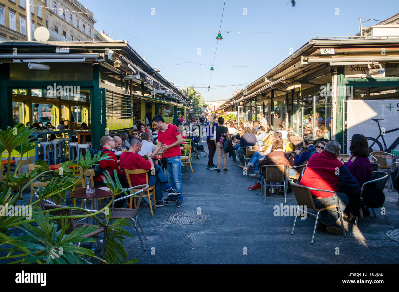 Some people having a drink in the Naschmarkt area in Vienna. Stock Photo