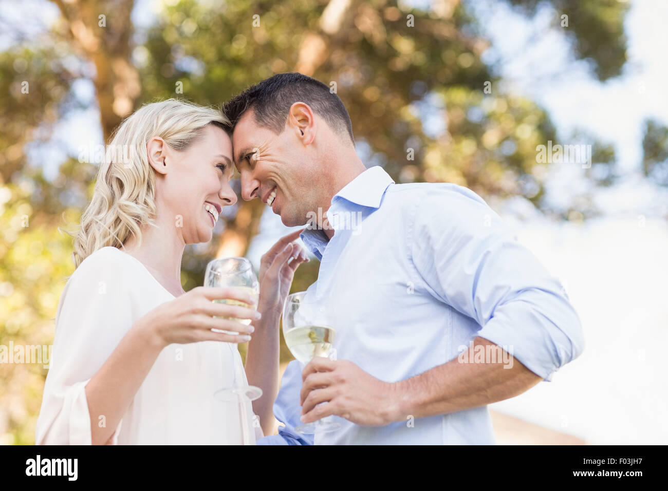 Smiling couple holding wine and looking intensively at each other Stock Photo
