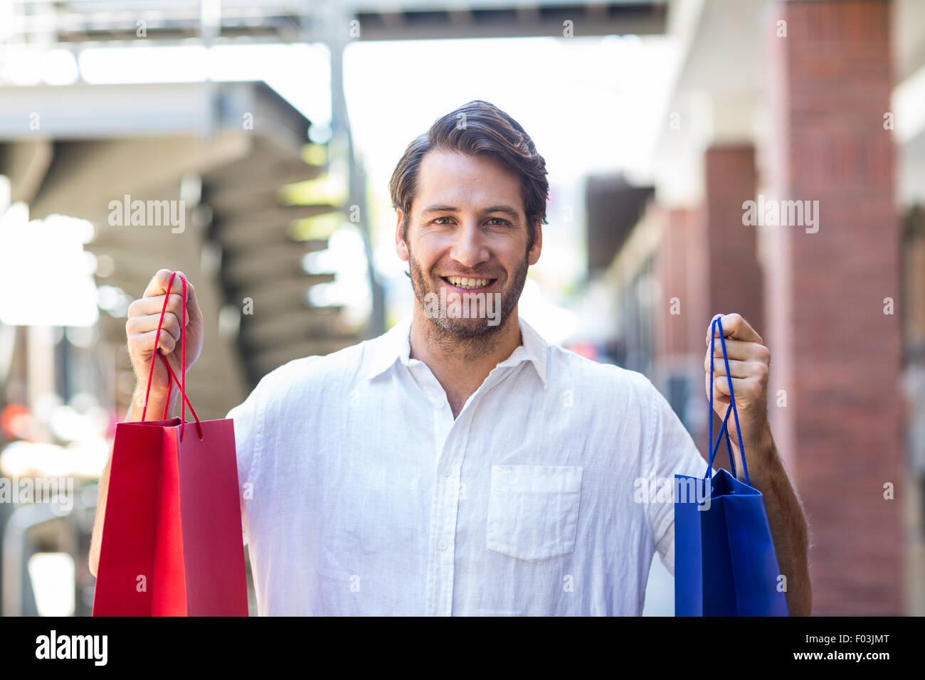 A happy smiling man with shopping bags Stock Photo - Alamy