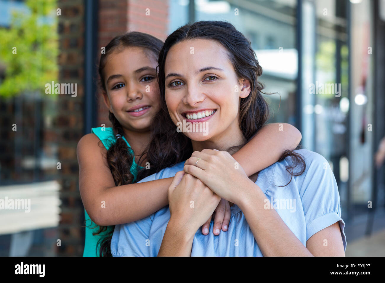 Portrait of a smiling mother and her daughter piggybacking Stock Photo