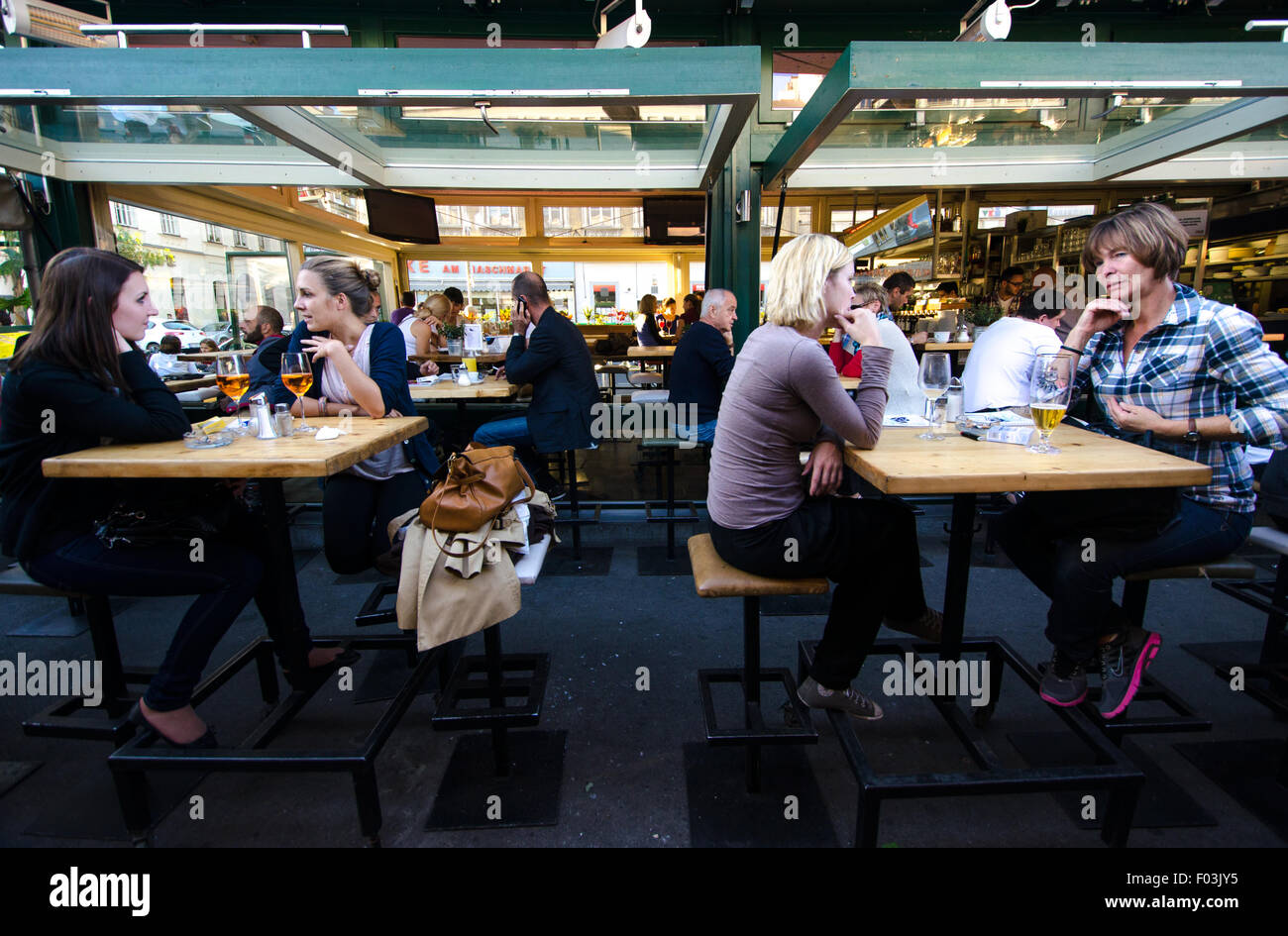People siting in one of the bars in Naschmarkt area in Vienna. Stock Photo
