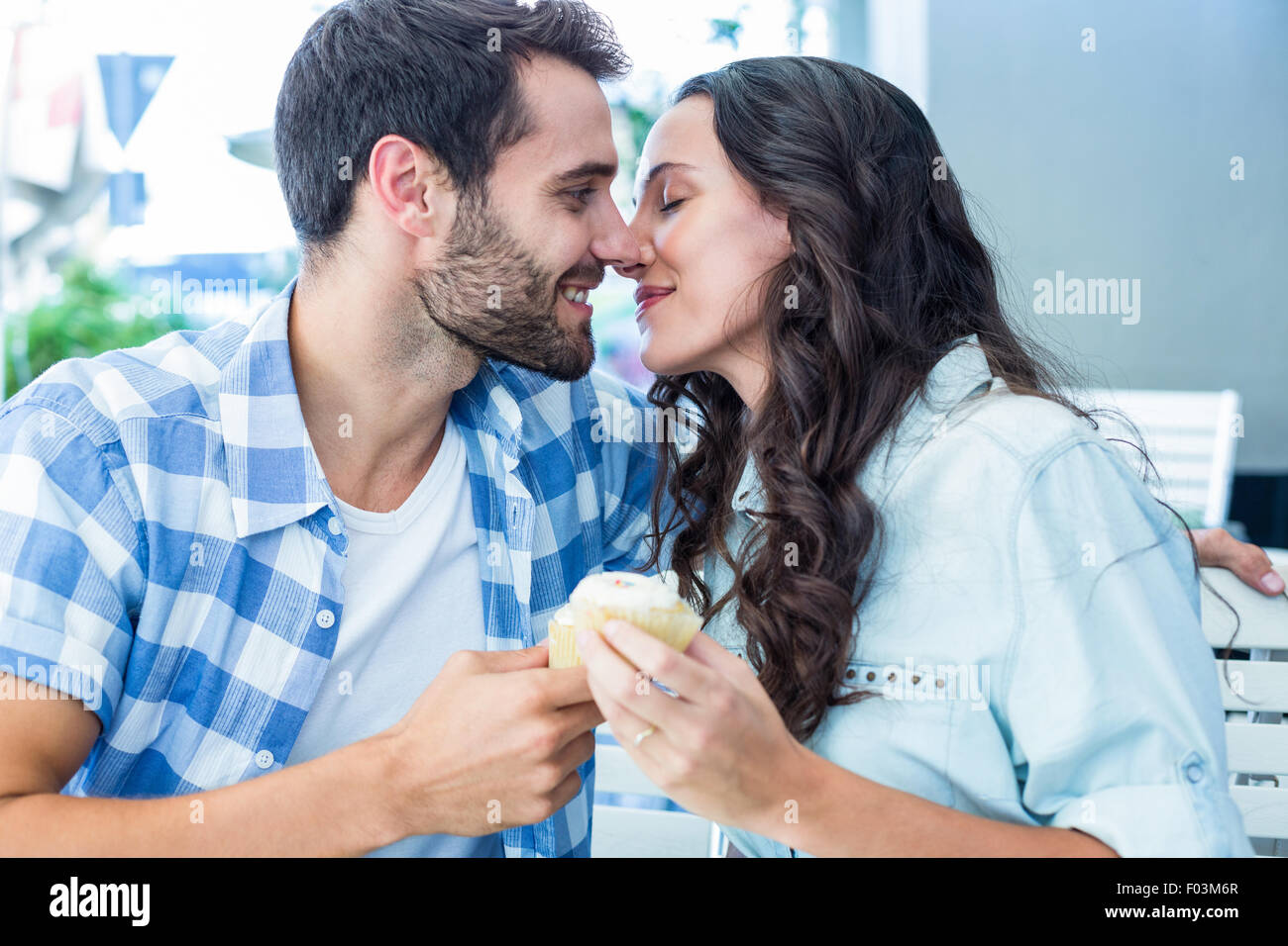 Couple kissing while holding cupcakes Stock Photo