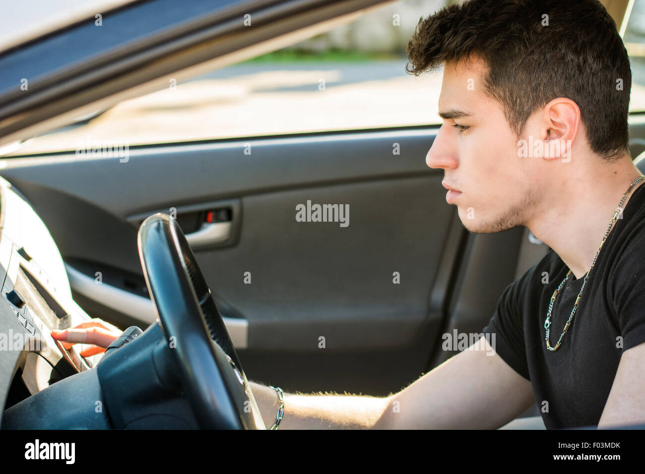 Handsome Young Man Driving a Car and playing music Stock Photo